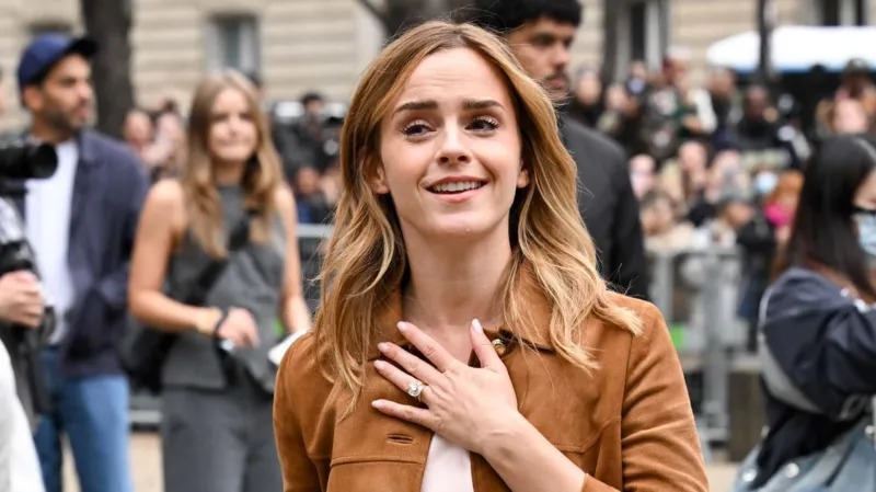 Emma Watson berpose di depan kamera di luar pertunjukan Miu Miu di Paris.