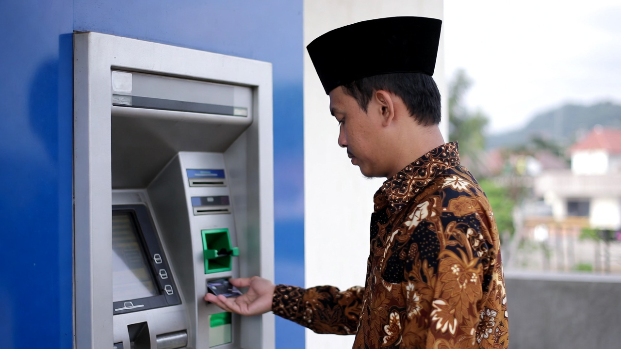 Ilustrasi orang sedang mengambil uang di ATM.
