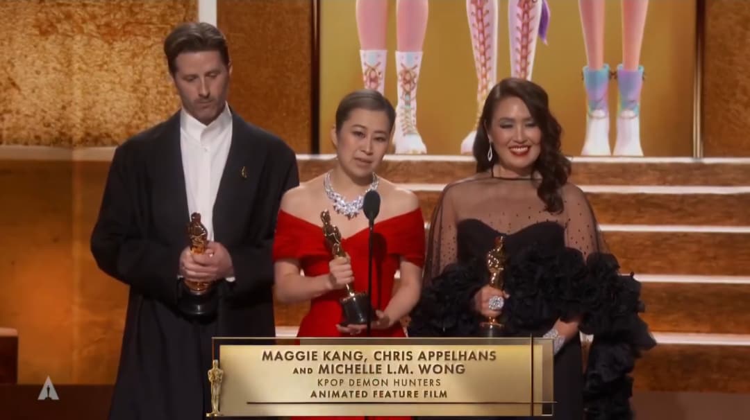 Produser Michelle L.M. Wong bersama sutradara Maggie Kang dan Chris Appelhans saat menyampaikan pidato kemenangan (X @TheAcademy).