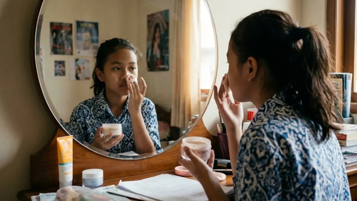 Seorang anak mengoleskan bedak di wajahnya sembari bercermin. (AI Generated)