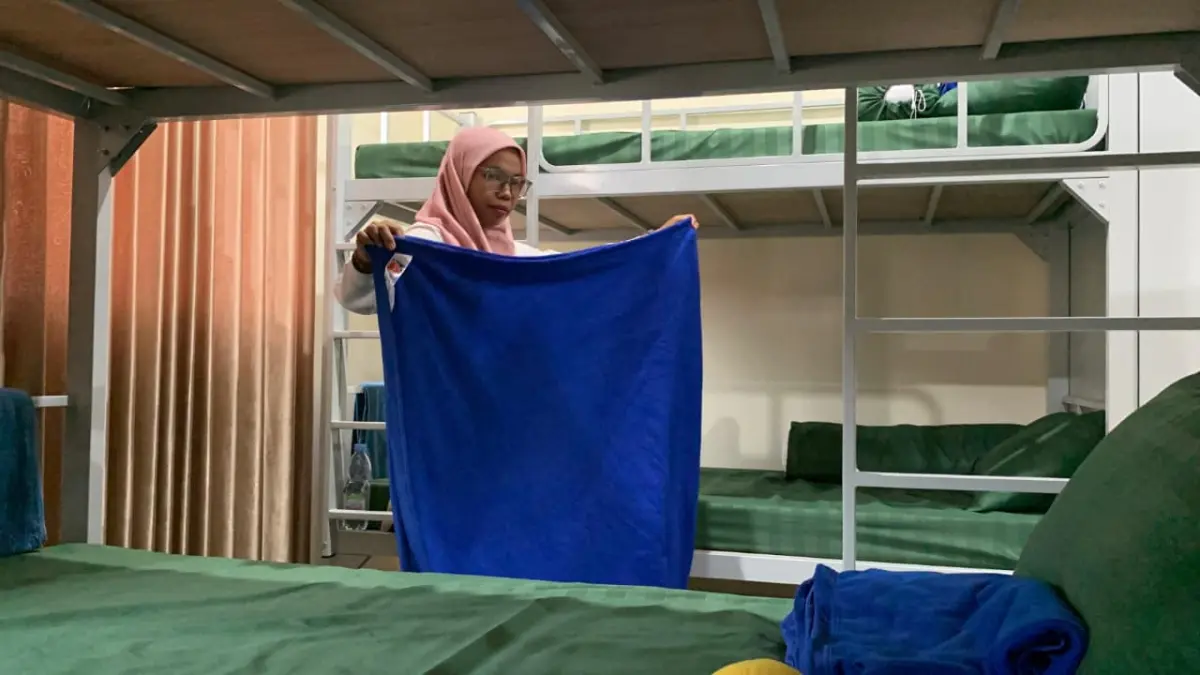 MERAPIKAN: Asih mengecek kondisi kamar siswa dan membersihkan asrama yang masih kotor. (Foto: ANOM BAGASKORO/RADAR JOGJA)