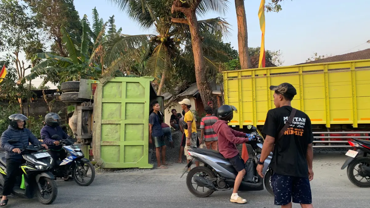 Warga bersama petugas terkait mengevakuasi truk yang terguling setelah terlibat kecelakaan di Jalan Yogyakarta–Wonosari Km 25, Padukuhan Bunder, Kapanewon Patuk. (Dzika Fajar/Radar Jogja) 