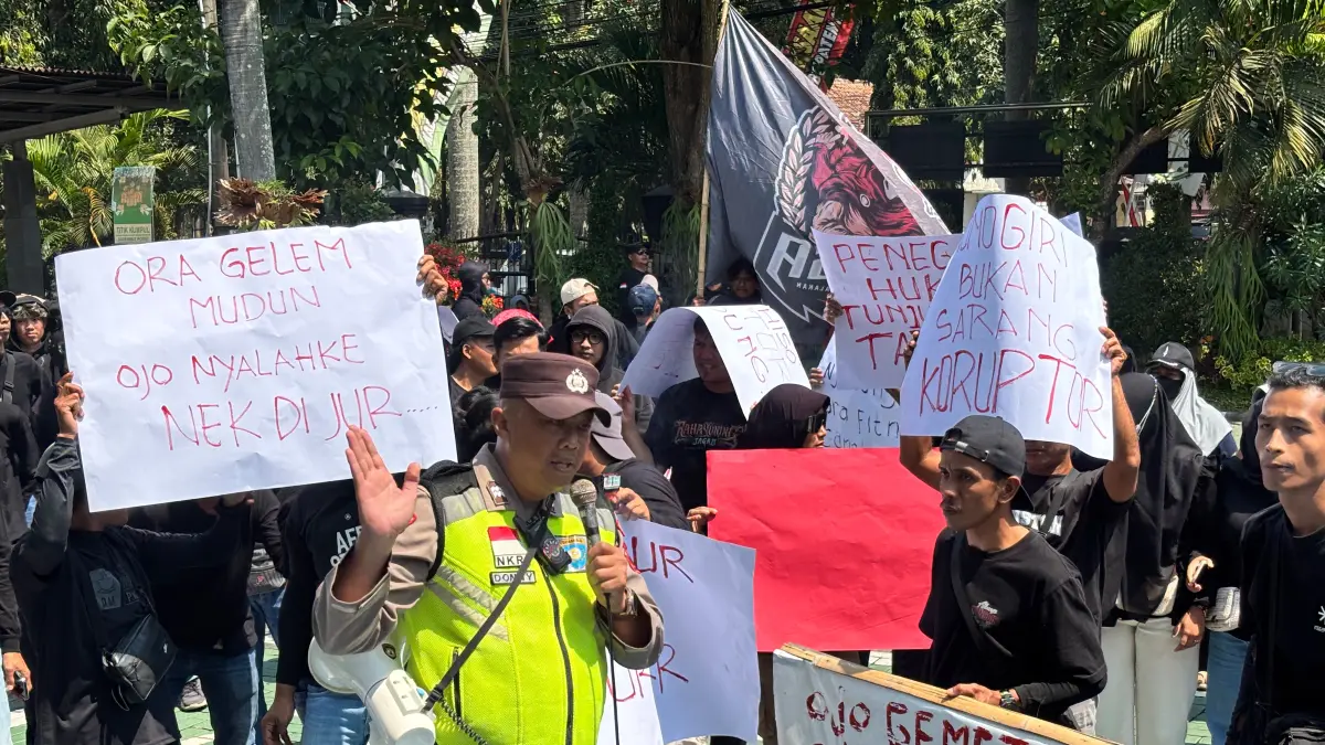 Warga membawa sejumlah poster yang meminta agar kejaksaan segera melanjutkan proses hukum kadesnya atas dugaan tindak pidana korupsi, Kamis (6/8/2026). (NAILA NIHAYAH/RADAR JOGJA) 