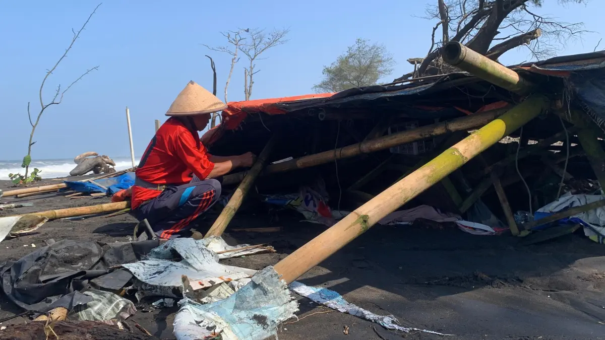 Warga setempat mengambil puing material bangunan kios yang dihantam gelombang tinggi. (ANOM BAGASKORO/RADAR JOGJA) 