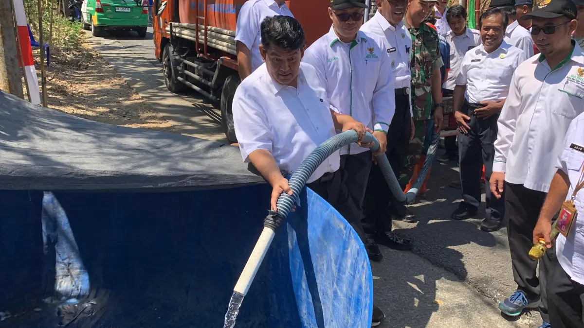 BERSIH: Bupati Kulon Progo menuangkan air bersih ke penampungan kolam yang akan diambil warga. (ANOM BAGASKORO/RADAR JOGJA) 
