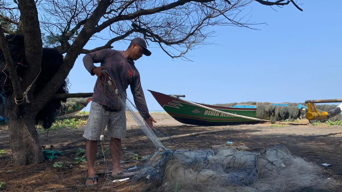 PERBAIKAN: Giyanto mengisi waktu dengan memperbaiki jaring, berharap setelah gelombang normal dapat langsung dipakai. (ANOM BAGASKORO/RADAR JOGJA) 