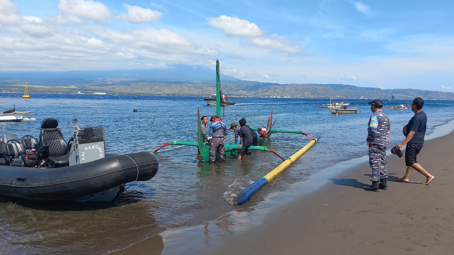 SELAMAT: Anggota TNI AL mengevakuasi enam warga yang tenggelam di Selat Bali, Minggu (3/12).