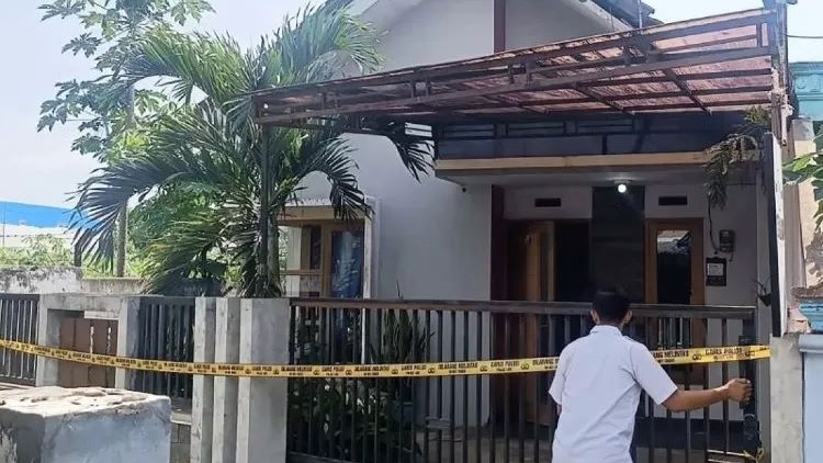SAKSI BISU: Rumah satu keluarga terdiri dari ayah, ibu dan anak di Malang dipasang garis polisi, Selasa (12/12).