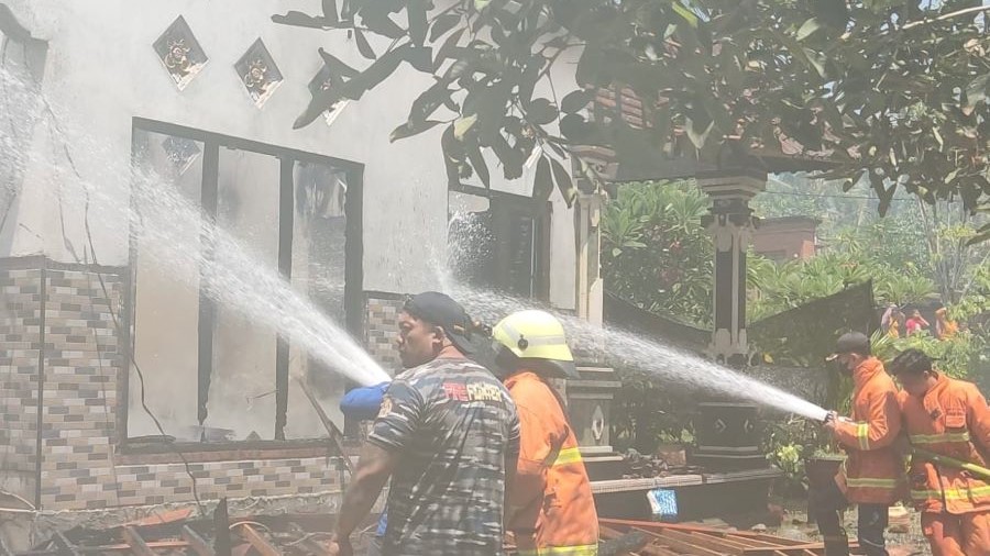 PADAMKAN API : Regu Damkar Jembrana berjibaku memadamkan api yang menghanguskan rumah dan gudang alat dekorasi di Banjar Berawantangi Taman, Desa Tukadaya, Kecamatan Melaya, Senin (18/12).