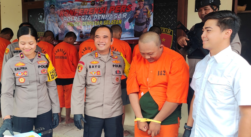 MENUNDUK: Bagus Indra hanya bisa menunduk lesu setelah kasus penipuan dan penggelapan yang dilakukannya dibeberkan di Mapolsek Denpasar Selatan, Bali.