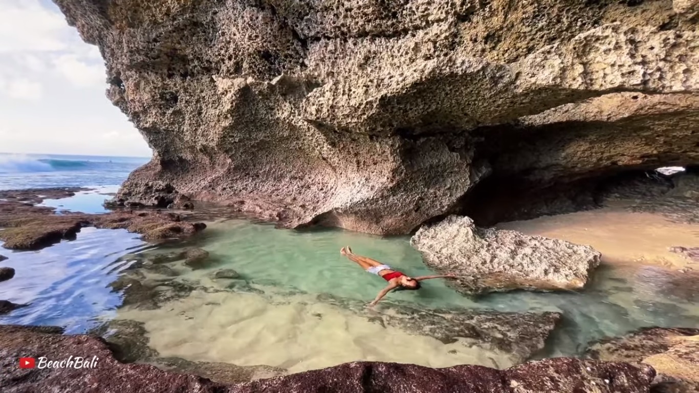 Natural infinity pool atau kolam renang alami di bawah tebing Pantai Balangan, Jimbaran, Bali.