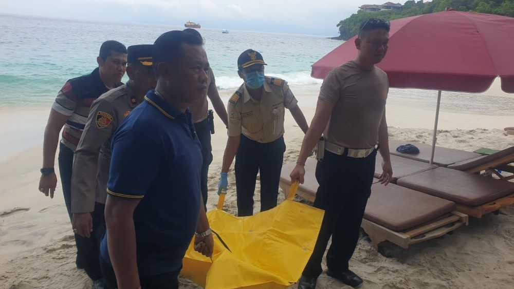 TEWAS SNORKELING: Petugas kepolisian mengevakuasi jenazah turis Rusia yang tewas snorkeling di Pantai Bias, Karangasem, Bali, Sabu (3/2).
