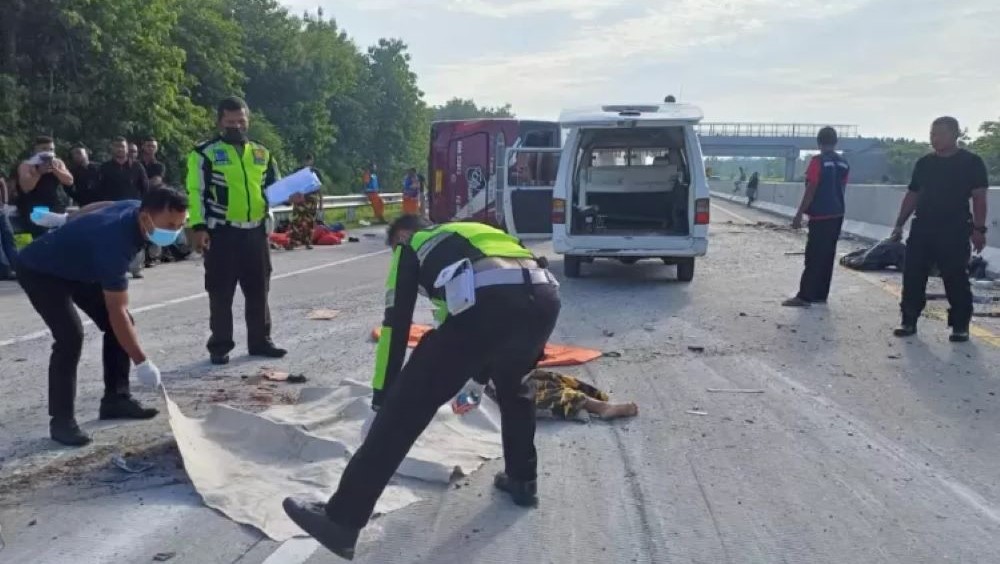 TRAGIS: Polisi dan petugas medis mengevakuasi korban kecelakaan rombongan Satgas Partai Hanura di Jalan Tol Ngawi, Jawa Timur.