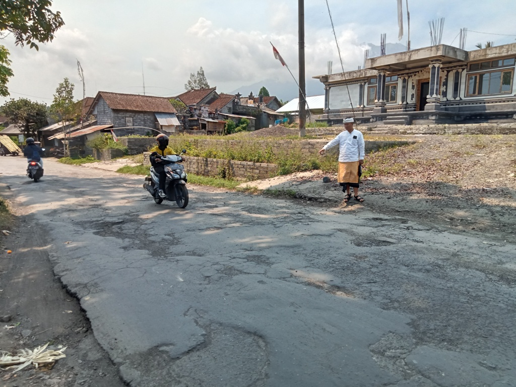 RUSAK: Kondisi jalan raya Selat yang berada di depan Kantor Camat Selat, Karangasem, Bali berlubang dan bergelombang.