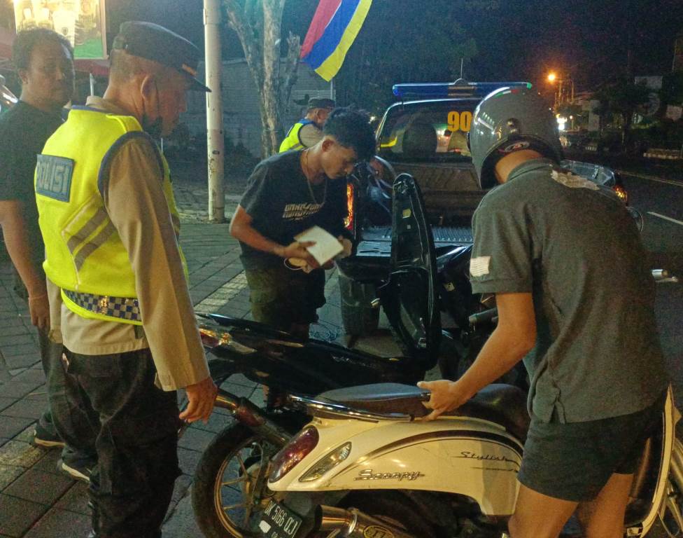 Angkut: Aparat mengangkut dua kendaraan yang terjaring saat pembubaran aksi balap liar di Jalan Gatsu Barat, Denpasar, Bali.