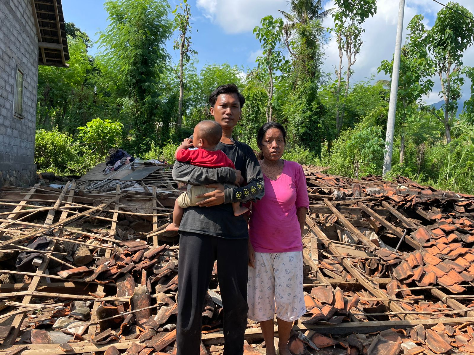 Kadek Suarjana bersama istri dan anaknya di rumahnya yang roboh, di Desa Patas, Buleleng, Bali.