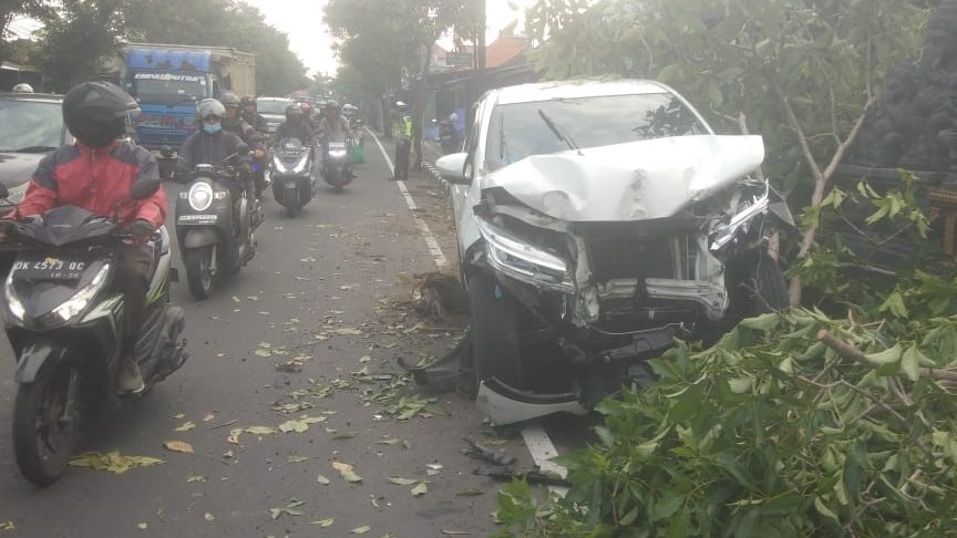 RINGSEK: Mobil Terios rusak berat bagian depan setelah menabrak pohon dan tukang sapu DLHK Badung.