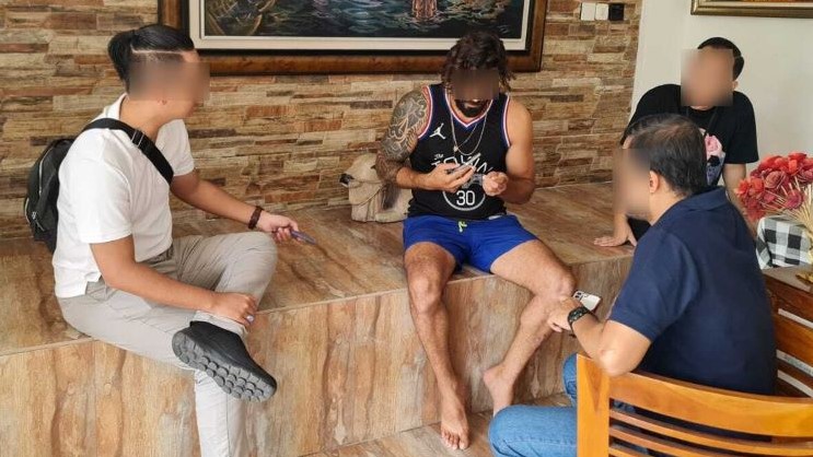 DIAMANKAN: Petugas Imigrasi Ngurah Rai Bali mengamankan SAB, turis Aljazair yang meresahkan warga.