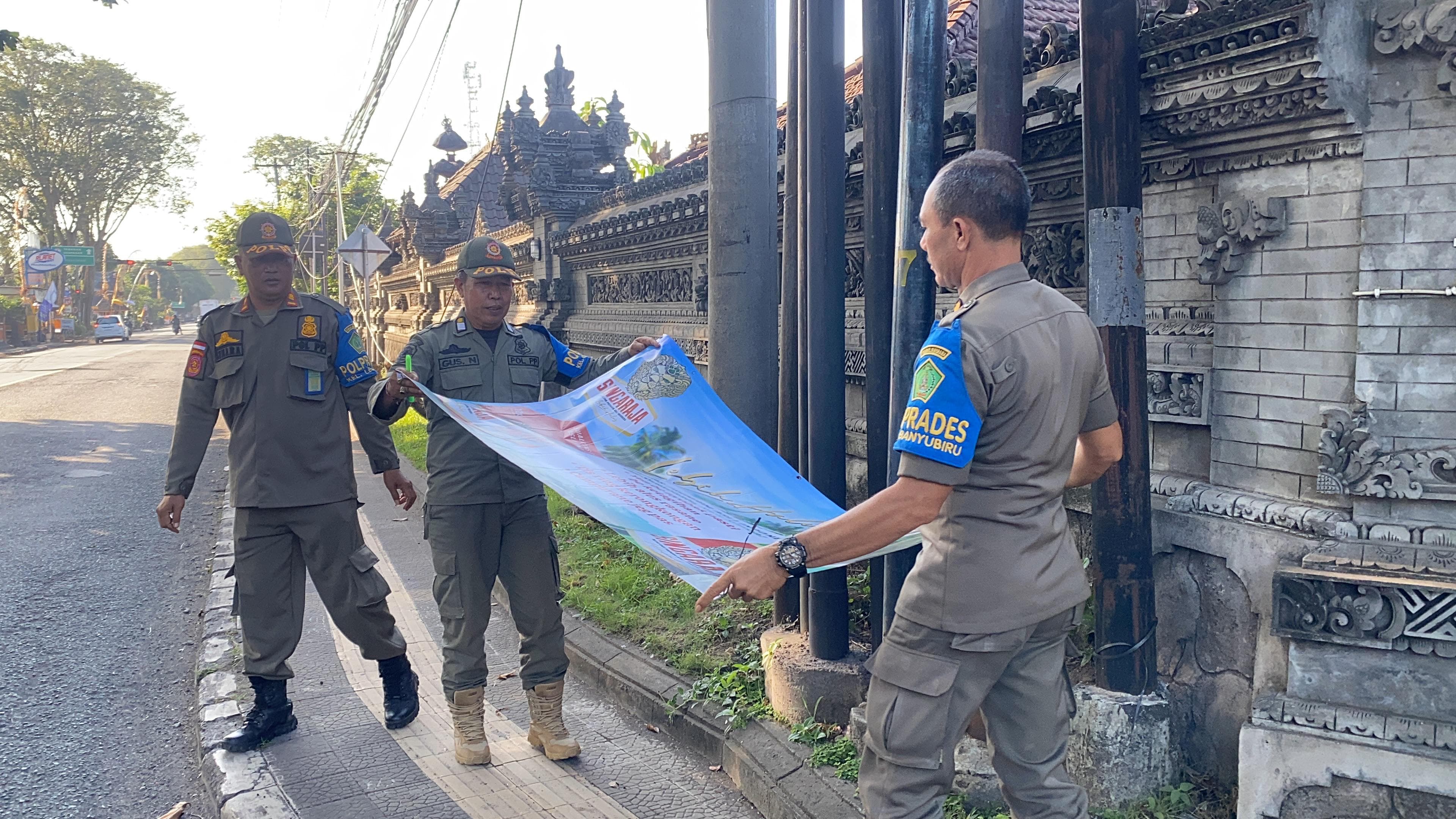 DICOPOT : Petugas Satpol PP Jembrana melakukan penertiban reklame disejumlah titik  di Kecamatan Negara dan Kecamatan Jembrana, Rabu (29/5).