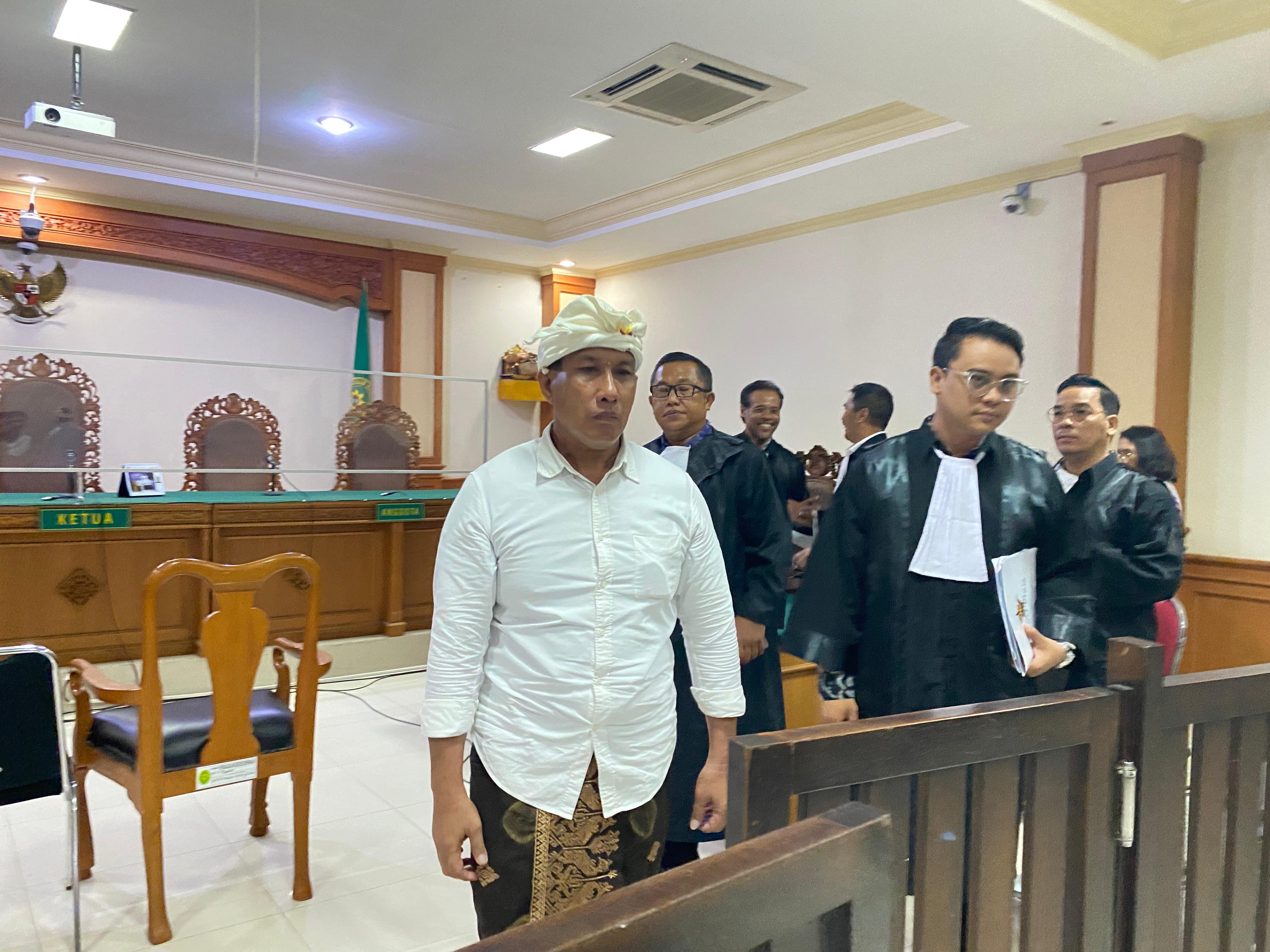 Terdakwa I Ketut Riana hadiri sidang perdana dengan mengenakan pakaian adat.