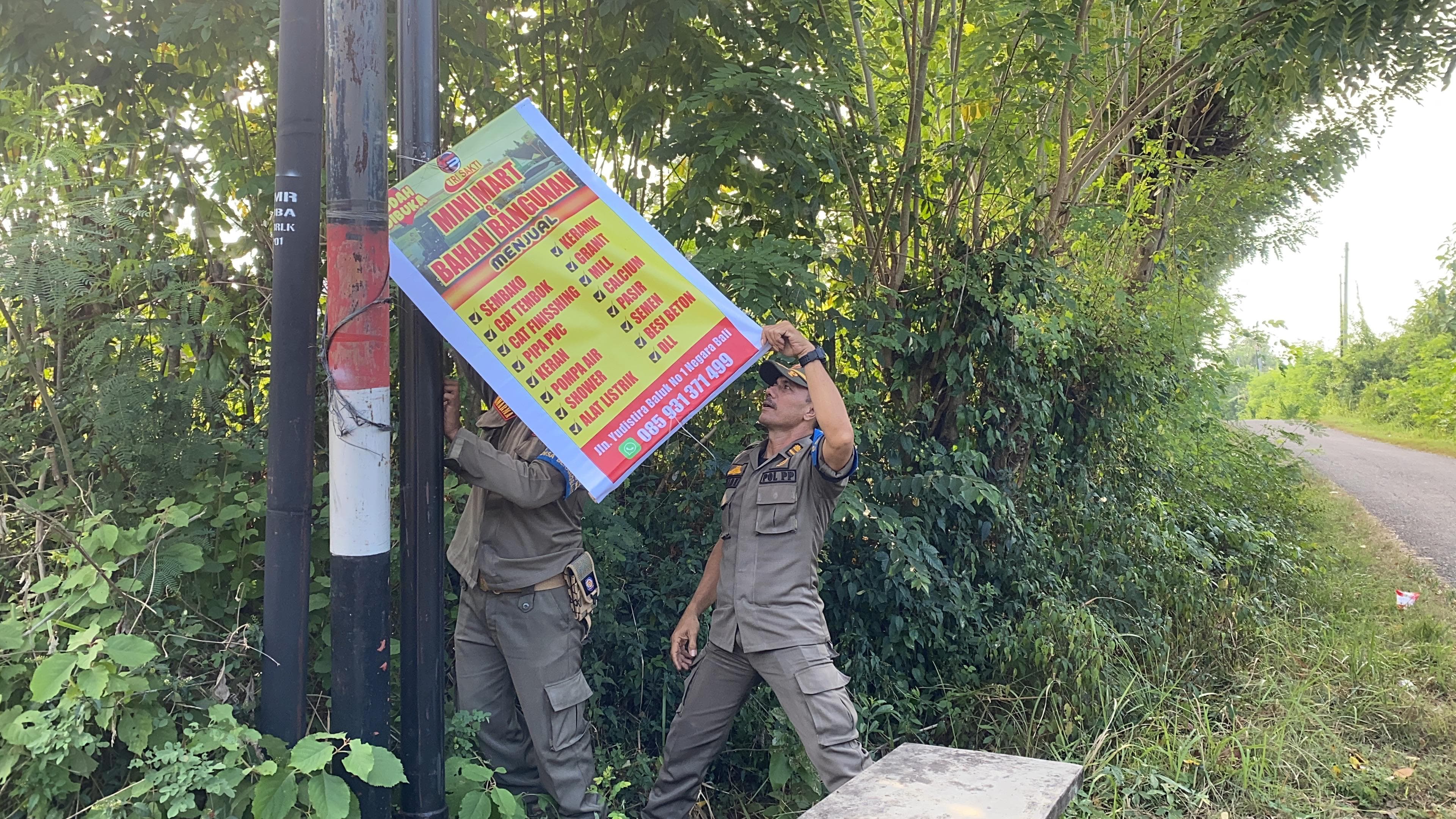 DICOPOT : Petugas Satpol PP Jembrana melakukan penertiban reklame disejumlah titik  di Kecamatan Negara dan Kecamatan Jembrana, Rabu (29/5).