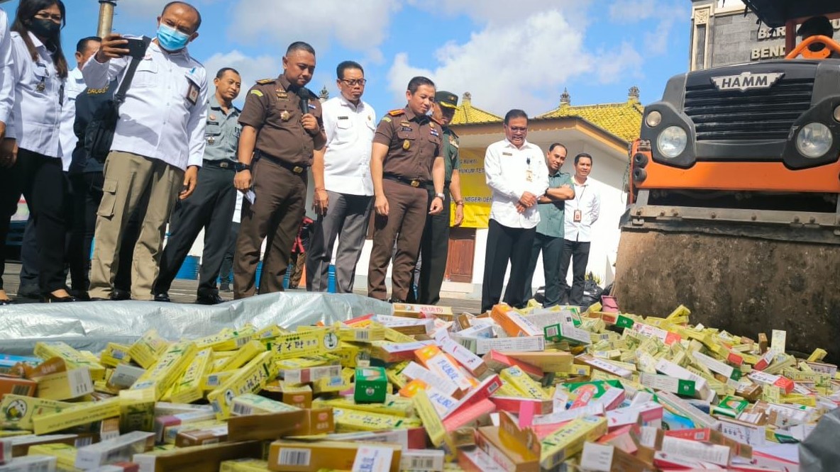 Kejari Denpasar musnahkan barang bukti perkara yang telah berkekuatan hukum tetap dengan cara dilindas alat berat dan dibakar.