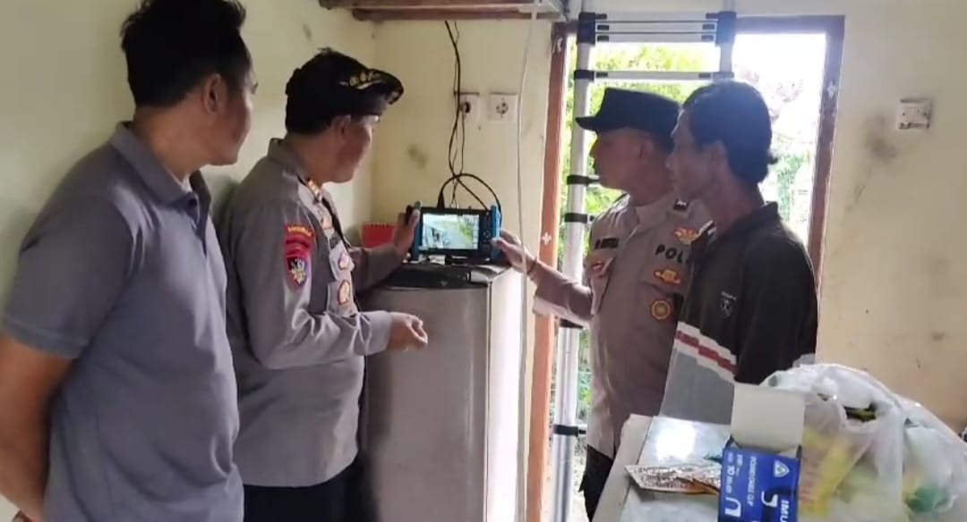 Anggota Polsek Selemadeg Timur mengawasi proses pemasangan kamera CCTV di Desa Tegalmengkeb, Tabanan, Senin (10/6)
