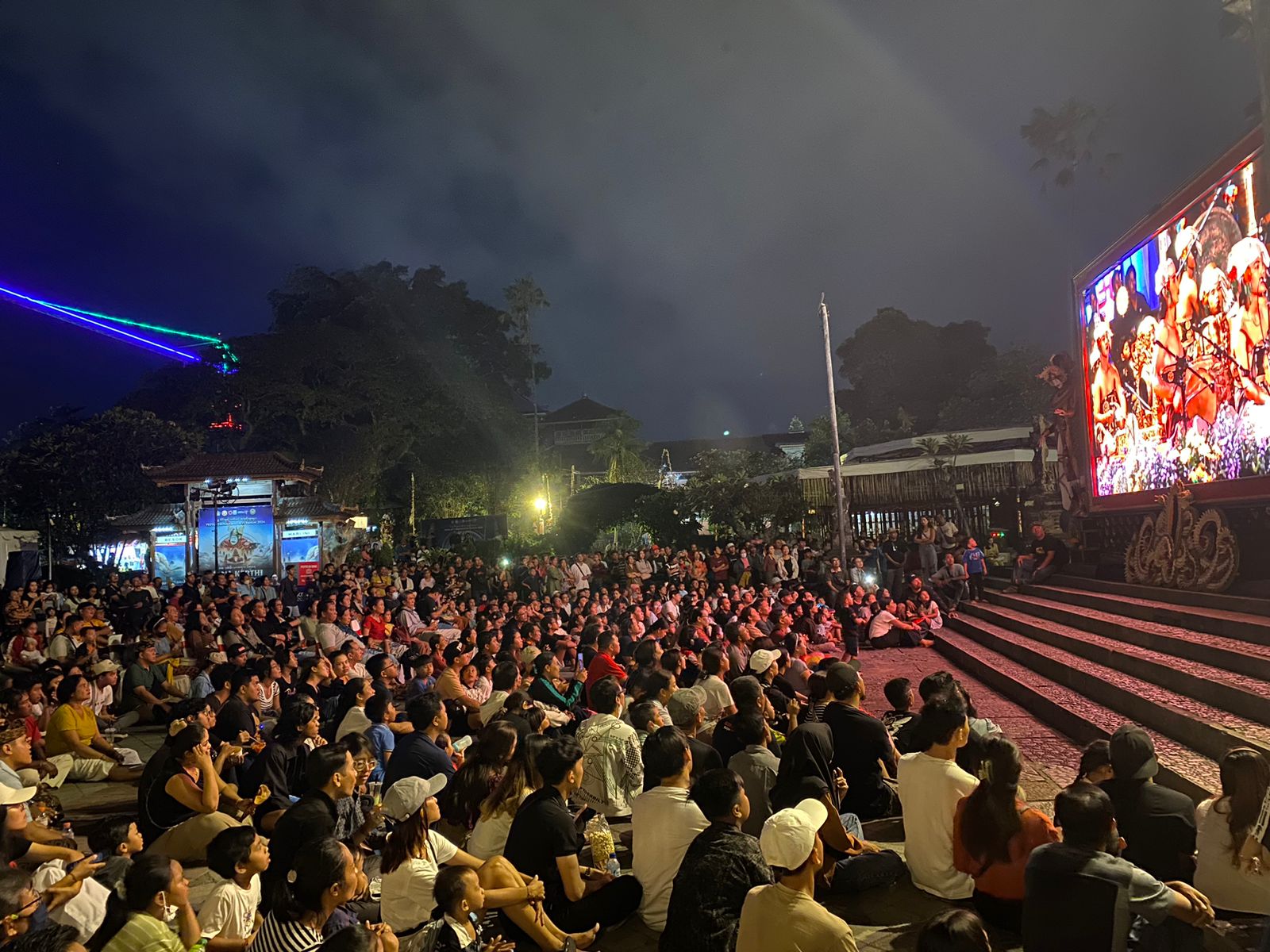 Antusias pengunjung menyaksikan pementasan seni melalui layar LED pada Pesta Kesenian Bali 2024.