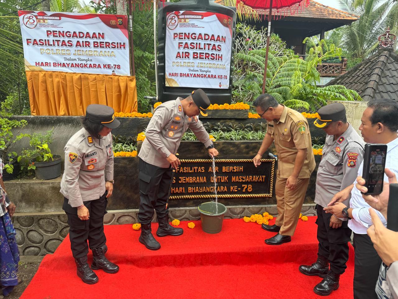 apolres Jembrana, AKBP Endang Tri Purwanto mencoba fasilitas sumber air bersih di Banjar Petapan Kaja, Desa Pergung, Kecamatan Mendoyo, Jembrana, Senin (24/6).