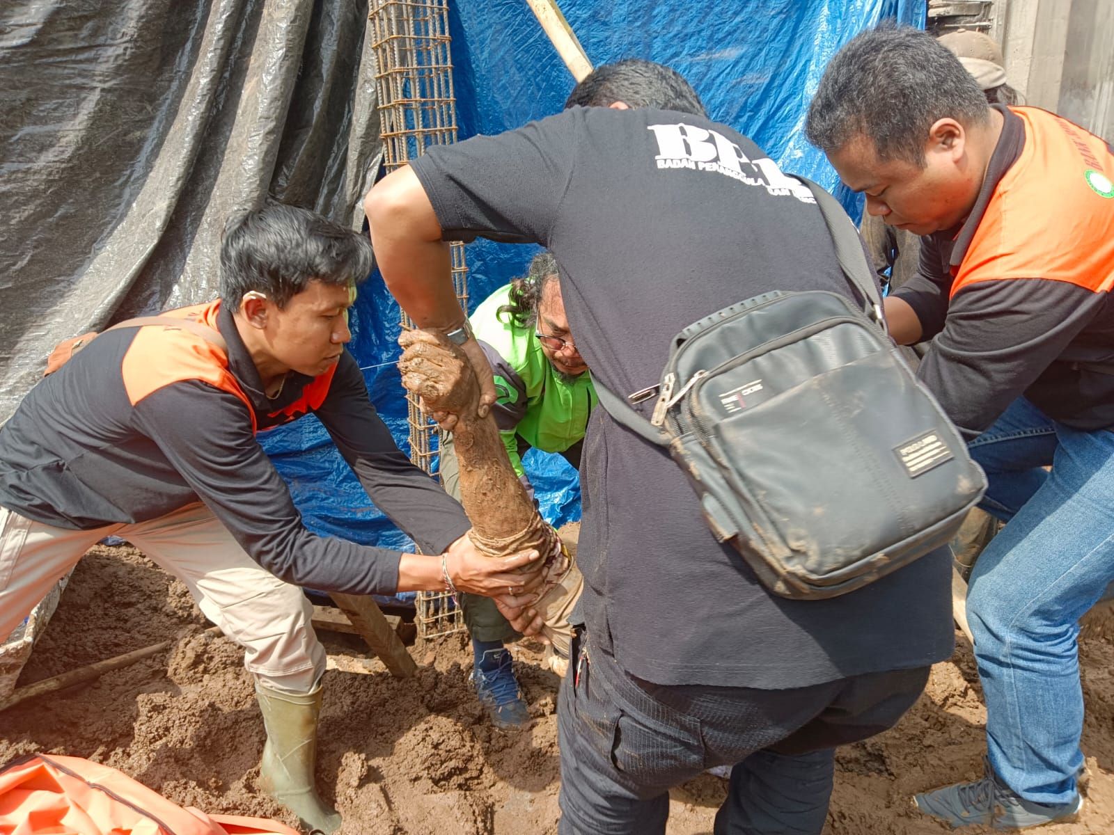 Petugas mengangkat jenazah Nyoman Santia yang tewas tertimbun tanah di Kediri Tabanan.