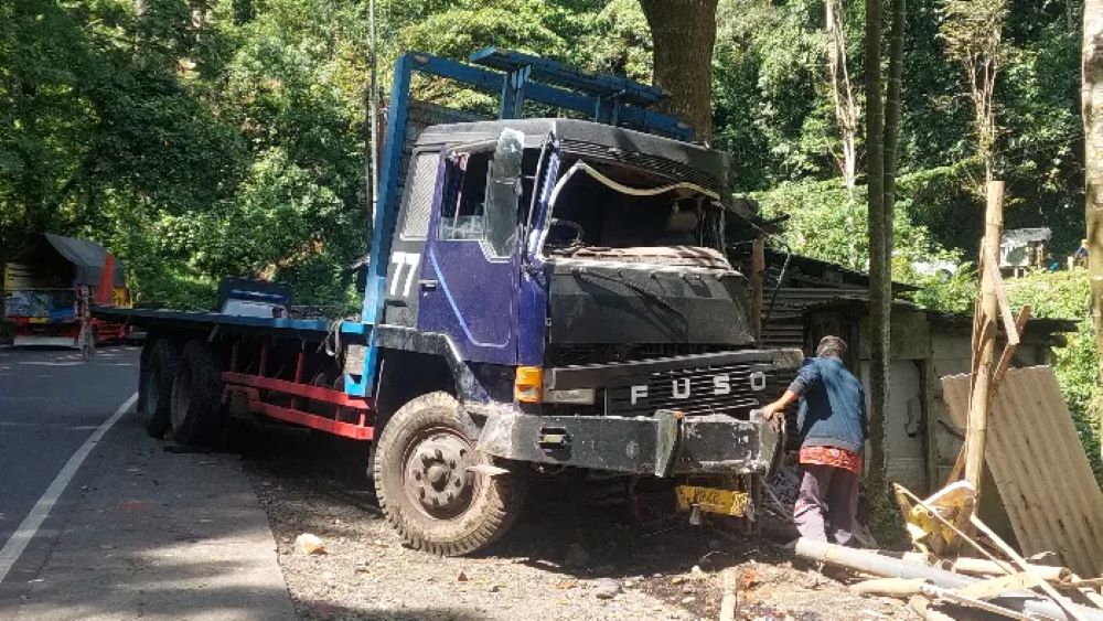 Truk Fuso yang dikemudikan Budi Hartono menabrak warung di Gumitir Jember hingga ringsek.