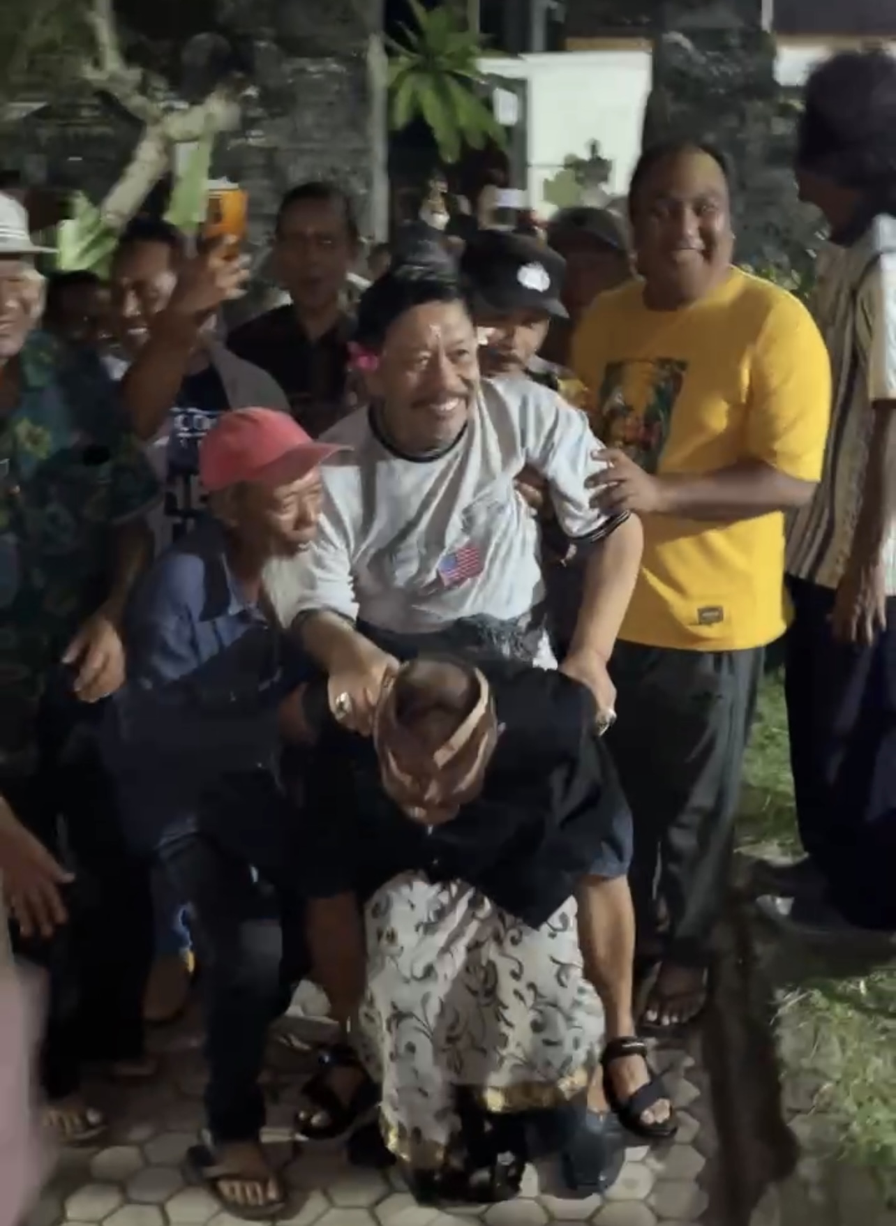 Mantan Bupati Jembrana I Gede Winasa saat digendong oleh I Ketut Tirta salah seorang simpatisan asal Kecamatan Melaya, Jumat (5/7/2024).