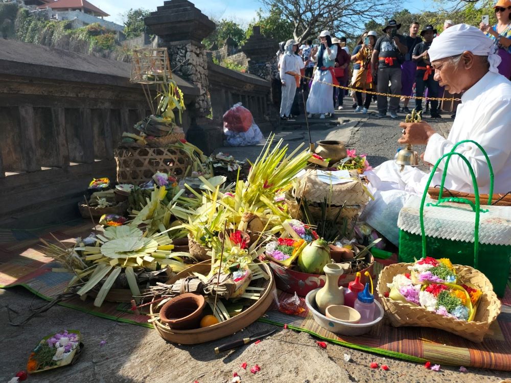 Prosesi upacara mecaru oleh Desa Adat Pecatu di depan stage kecak Pura Luhur Uluwatu, Jumat (30/8/2024).