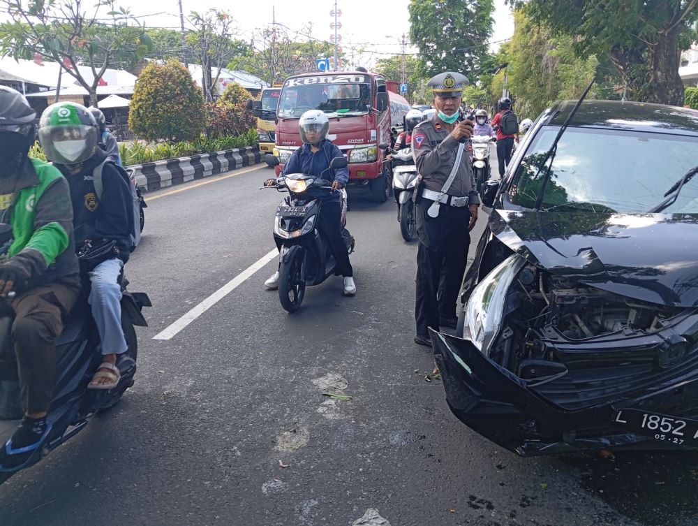 Bagian depan mobil yang dikendarai Ferdi ringsek usai menabrak trotoar dan pohon.