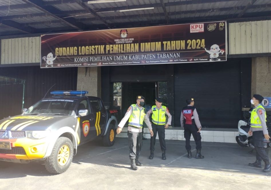 Polisi berjaga di gudang logistik KPU Tabanan yang kembali menggunakan gedung bekas Hardys.