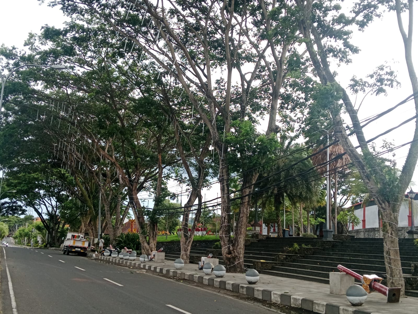 LAMPU: DLH Karangasem pasang lampu bergelantungan di pohon yang ada di Jalan Veteran, Kelurahan Padangkerta.