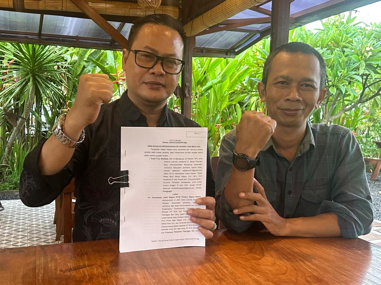 Kuasa hukum korban Dewa Agus Satrya Wijaya dan ayah korban I Gusti Putu Mudiasa menunjukkan putusan PN Negara terhadap PLN.