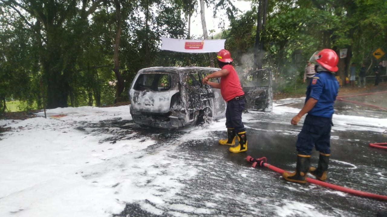 TERBAKAR: Mobil Nisan Livina yang dikemudikan Bambang Sumantri terbakar di Jalur Amlapura-Singaraja tempat di Desa Ababi, Abang, pada Selasa (17/12).