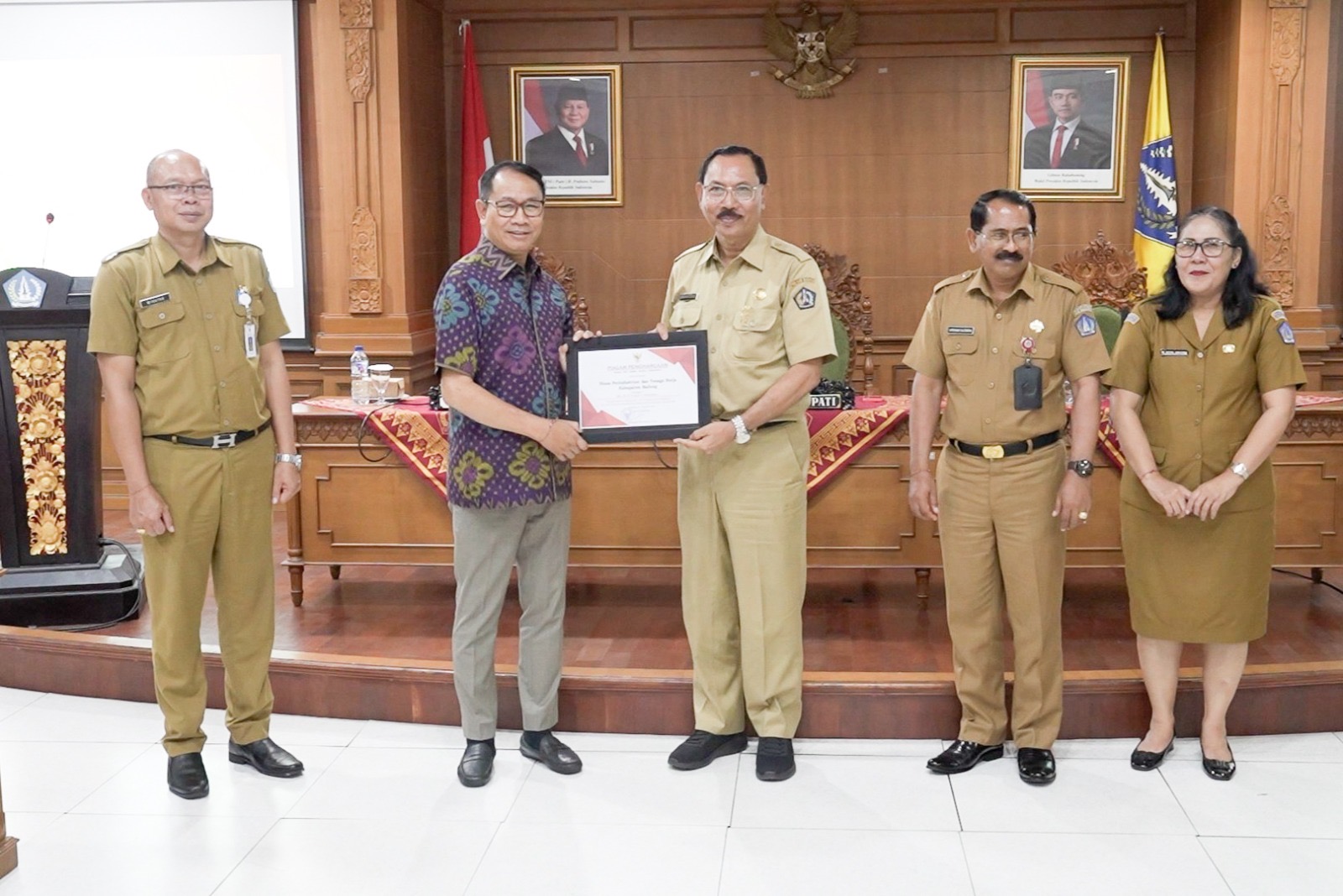 PENGHARGAAN: Wabup Suiasa saat menyerahkan Penghargaan Terkait Hasil Pengawasan Kearsipan Internal dan Penyusutan Arsip Daerah Tahun 2024 di Ruang Rapat Kriya Gosana Puspem Badung, Senin (23/12).