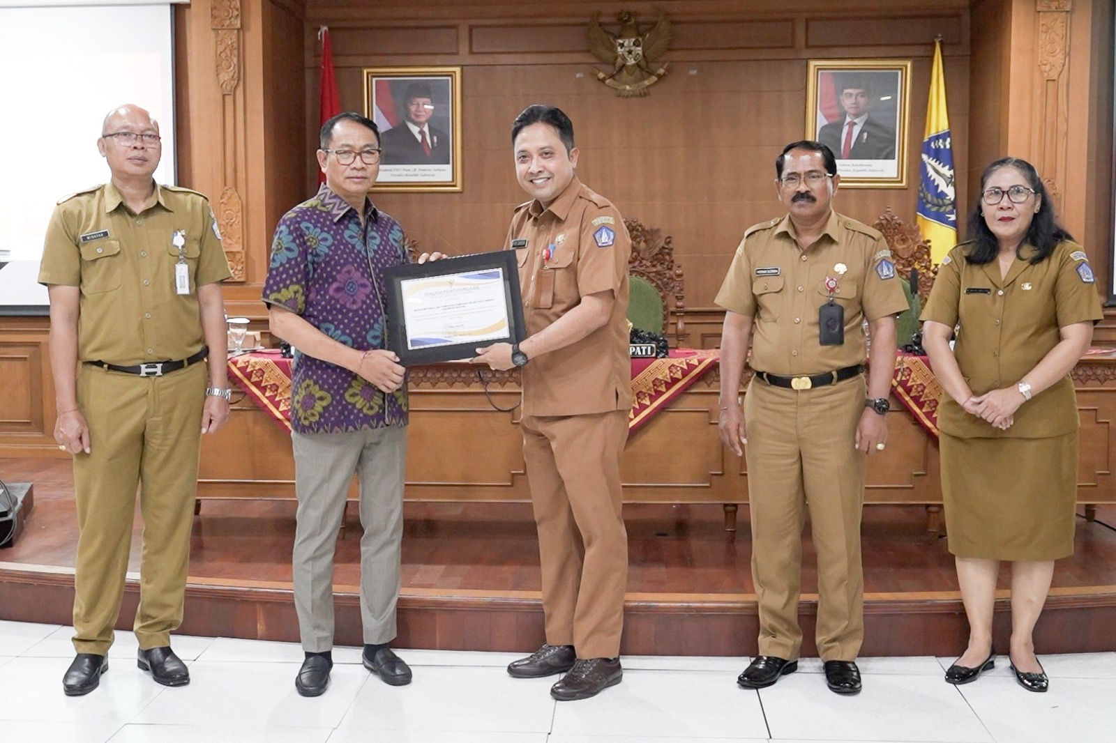 PENGHARGAAN: Wabup Suiasa saat menyerahkan Penghargaan Terkait Hasil Pengawasan Kearsipan Internal dan Penyusutan Arsip Daerah Tahun 2024 di Ruang Rapat Kriya Gosana Puspem Badung, Senin (23/12).