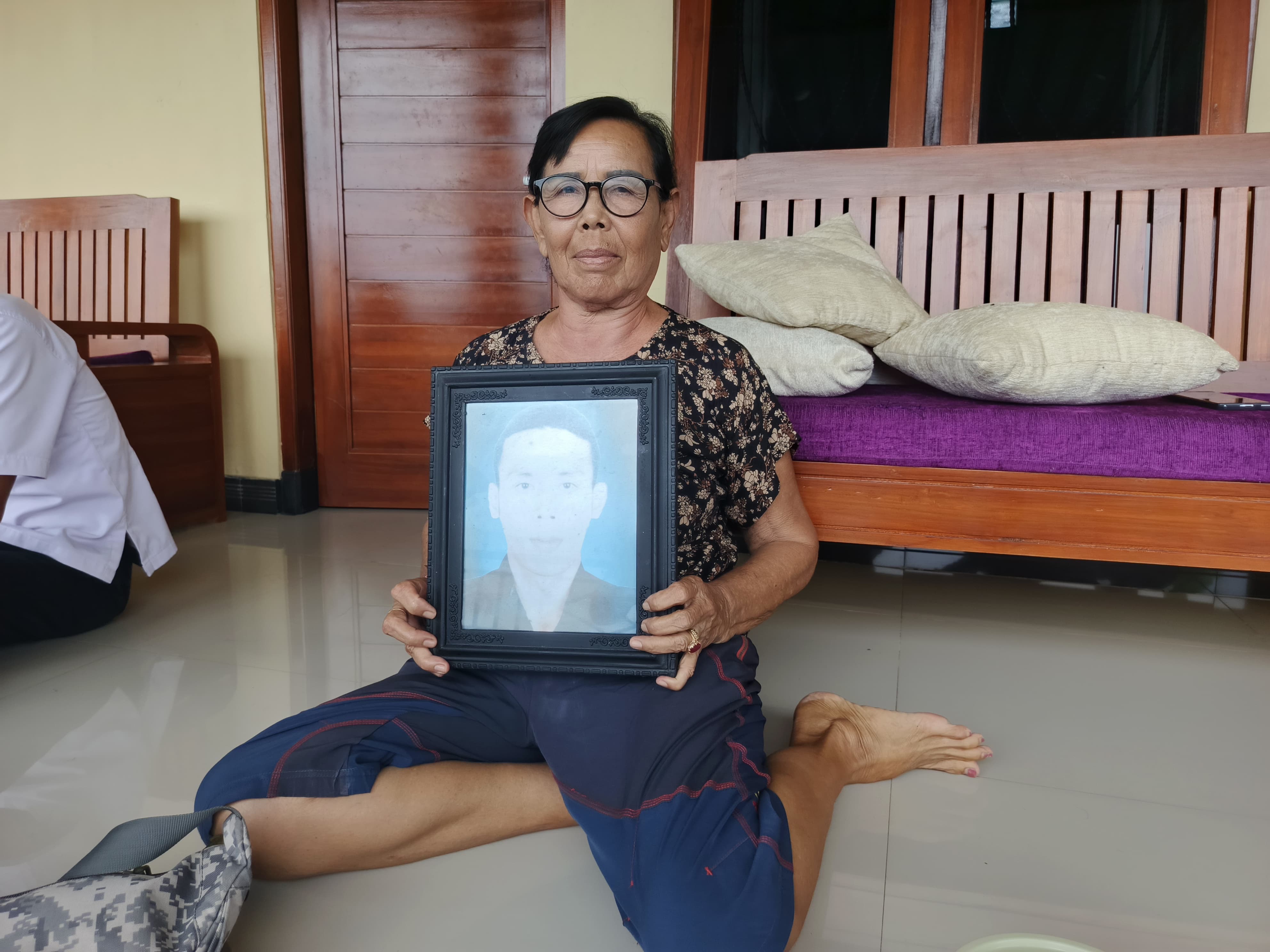 Ni Ketut Wandi (64) bersama foto almarhum Made Arya yang meninggal beberapa waktu lalu di Amerika Serikat.