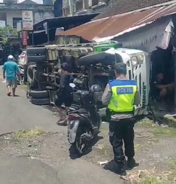 Petugas kepolisian melakukan olah tkp truk oleng timpa ruko di Selemadeg Timur, Tabanan.