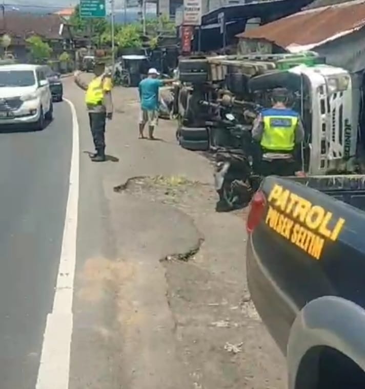 Petugas kepolisian melakukan olah tkp truk oleng timpa ruko di Selemadeg Timur, Tabanan.