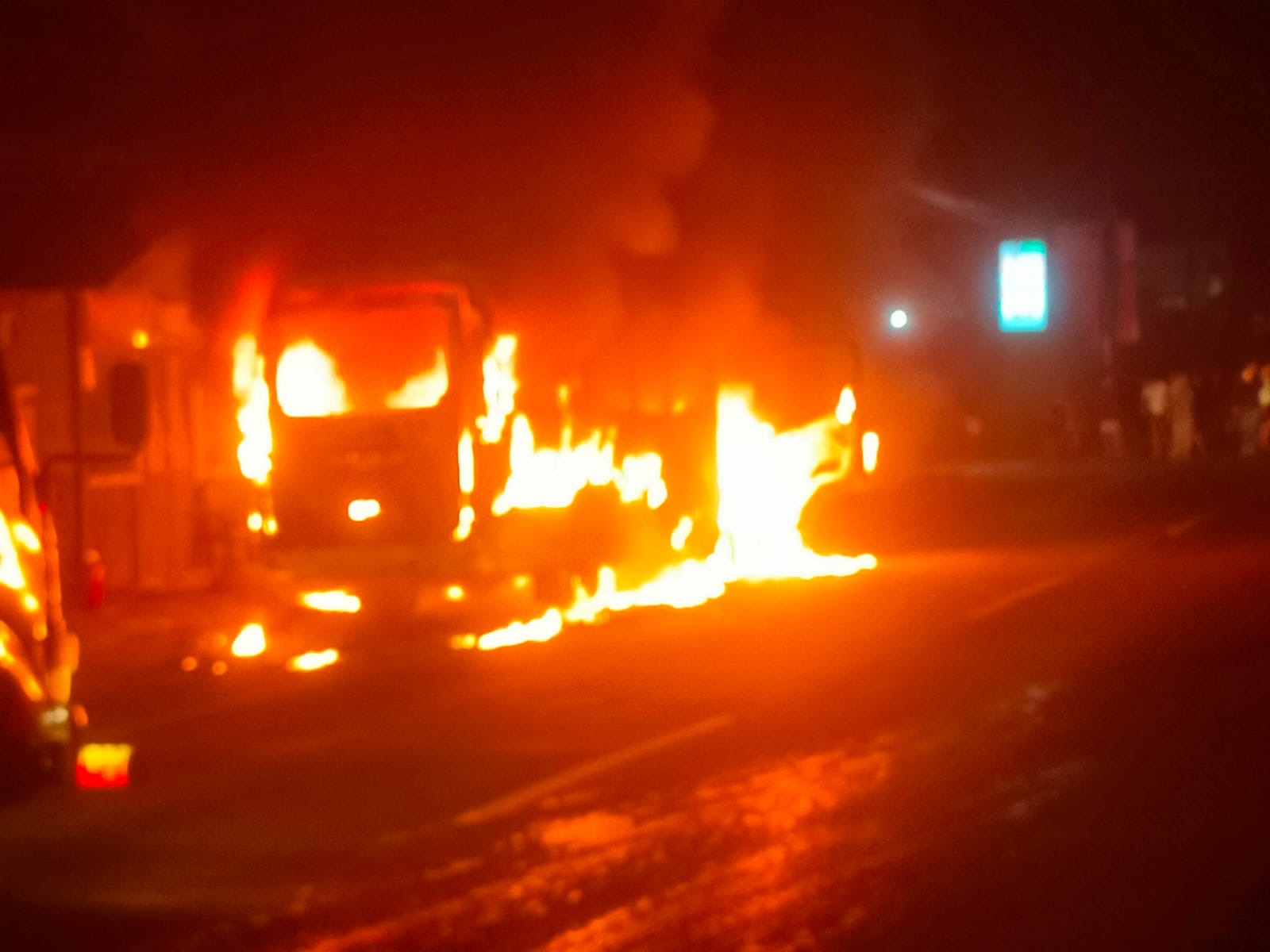 TERBAKAR : Mobil Travel yang terbakar dan api merembet ke tempat usaha potong rambut di Desa Banyubiru, Kecamatan Negara, Jembrana, Minggu (26/1/2025).