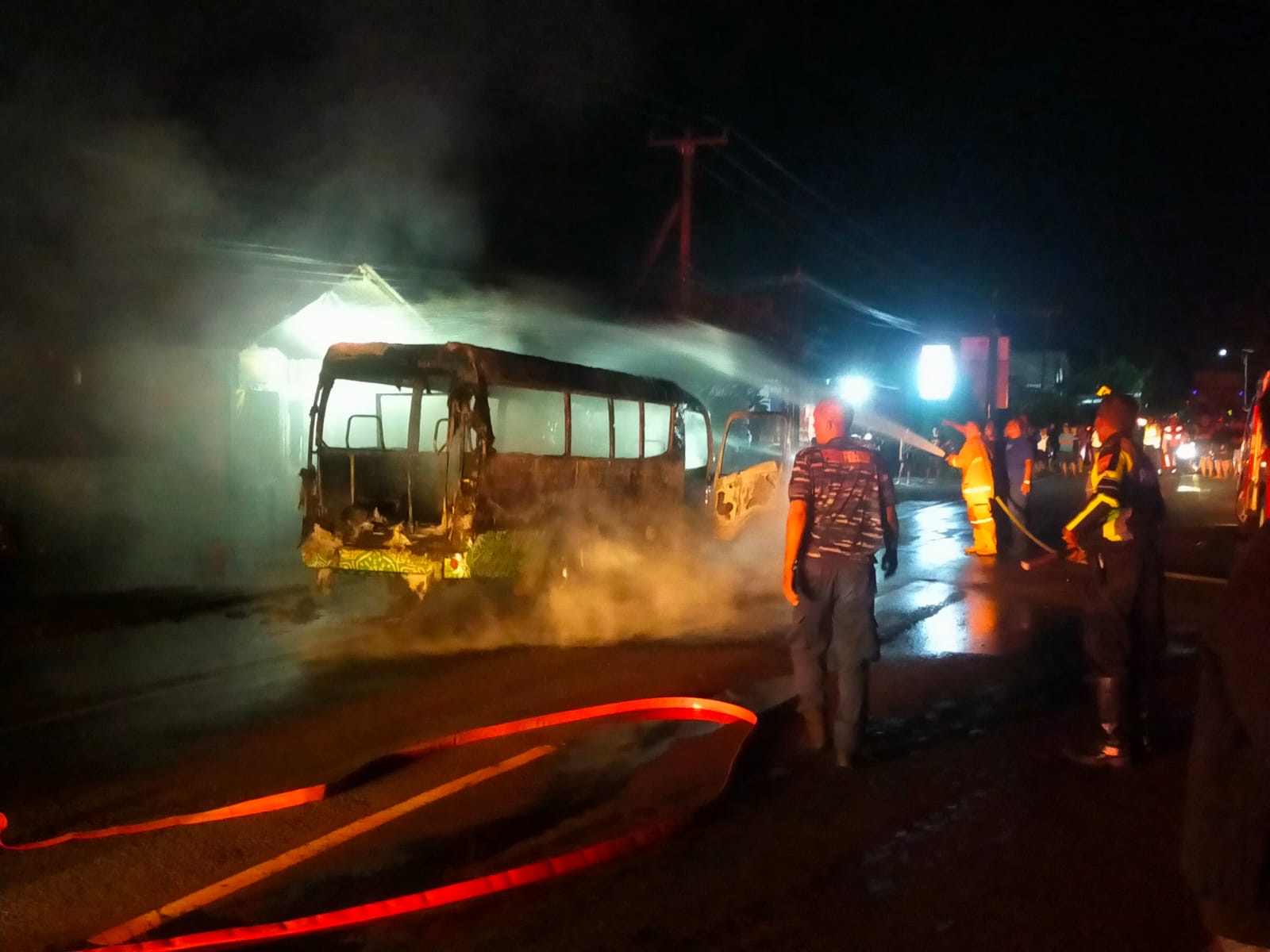 TERBAKAR : Mobil Travel yang terbakar dan api merembet ke tempat usaha potong rambut di Desa Banyubiru, Kecamatan Negara, Jembrana, Minggu (26/1/2025).
