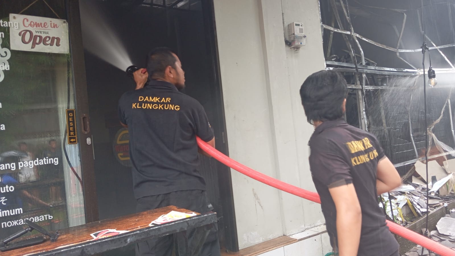 TERBAKAR : Petugas Damkar berupaya memadamkan api yang membakar resto pizza dan burger di Klungkung, Jumat (31/1/2025).