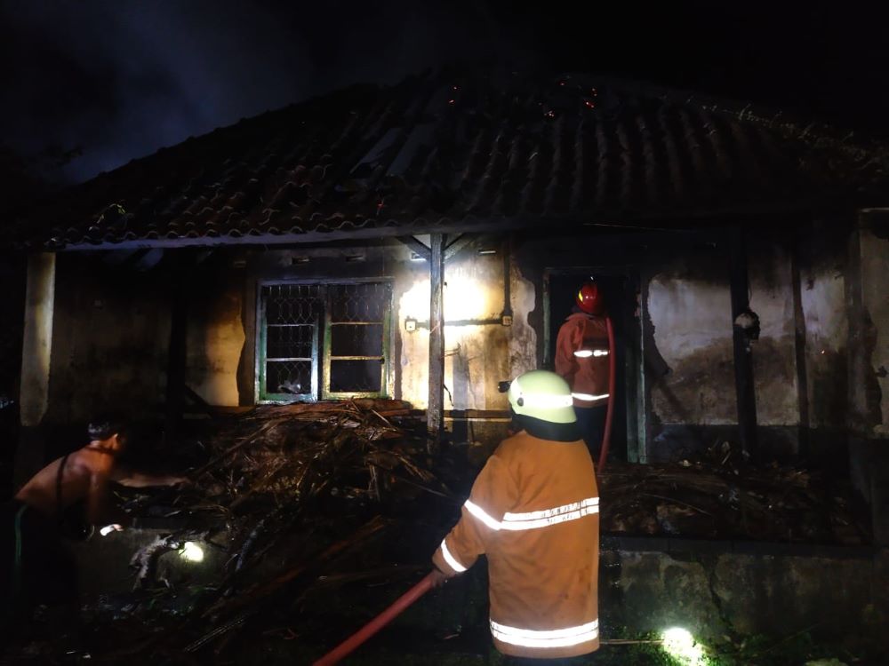 Petugas pemadam kebakaran memadamkan api di rumah warga Karangasem.