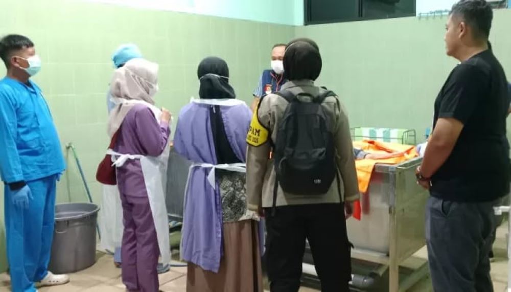 Petugas medis didampingi kepolisian memeriksa jasad Aji Pangestu yang ditemukan meninggal bersimbah darah di masjid Karanganyar.