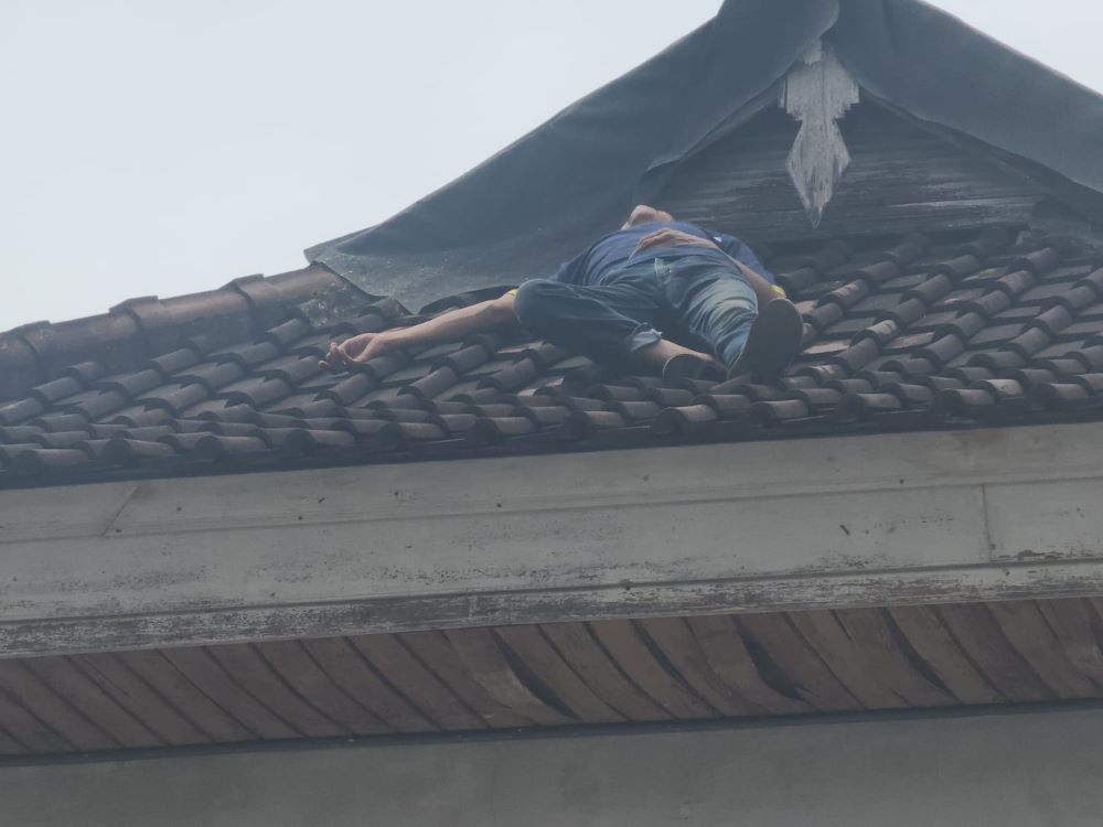 Taufik tertidur di atas genteng karena panik diteriaki warga saat masuk rumah orang di Panjer Denpasar.