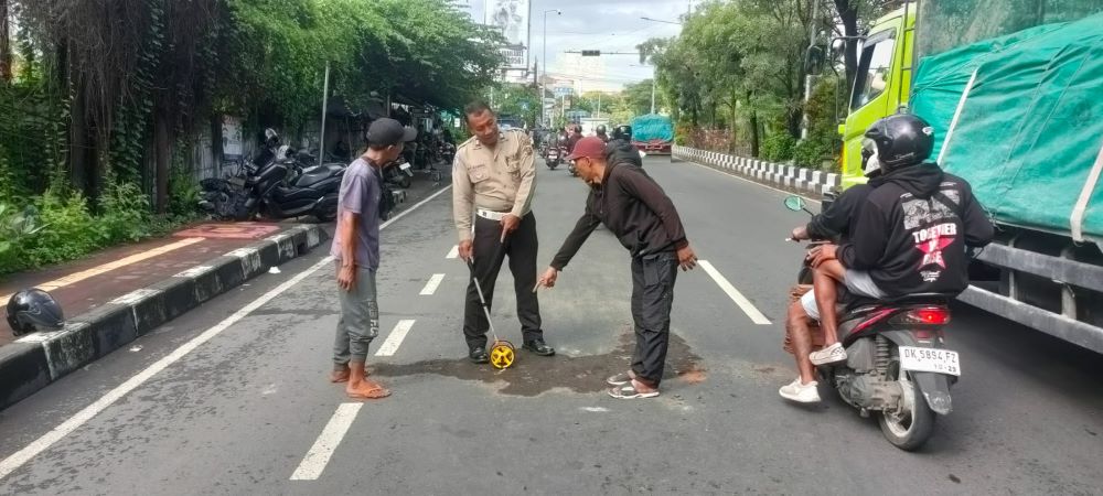 Polisi melakukan olah TKP kecelakaan tragis di Denpasar yang mengakibatakan Ni Kadek Ayu Mariani meninggal.